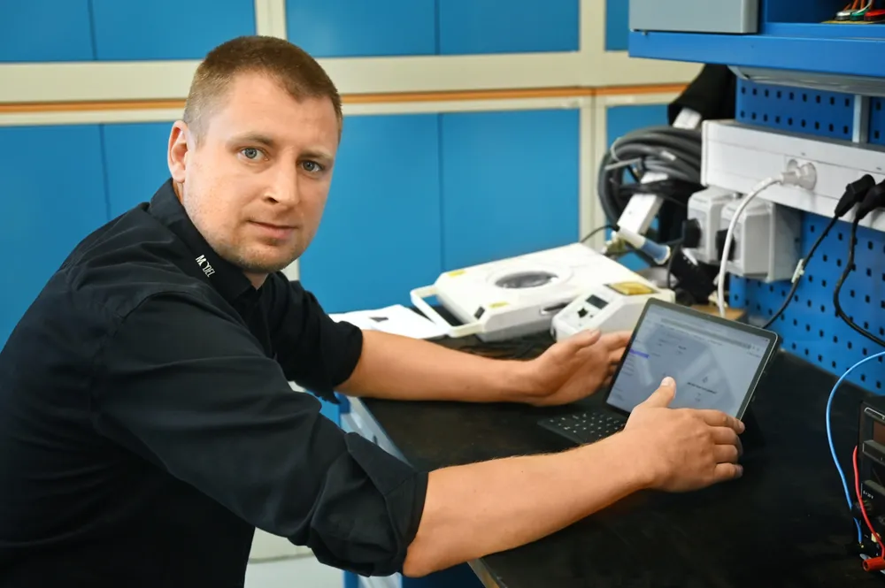 Kamil Fedor at a maintenance workbench with Edmund on a tablet